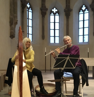 Gabriele Weigel an der Harfe und Stephan Iglisch mit der Querflöte musizieren in einem Kirchenraum.