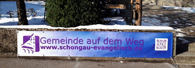 Ein Banner vor der Kirche mit Schirftzug: Kirche auf dem Weg