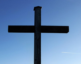 Das große Holzkreuz am Schongauer Galgenbichl vor blauem Himmel