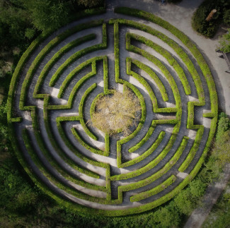 Ein rundes Labyrinth aus grünen Hecken von Oben gesehen.