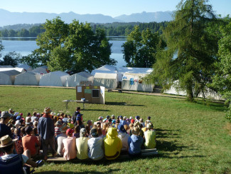 Blick auf eine Gruppe Kinder, im Hintergrund sind Zelte und der Staffelsee