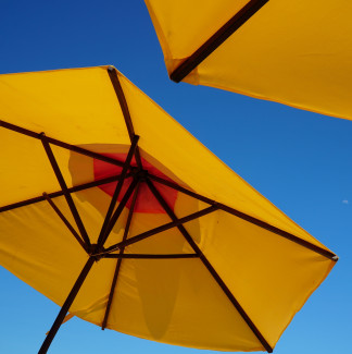 gelbe Sonnenschirme vor blauem Himmel